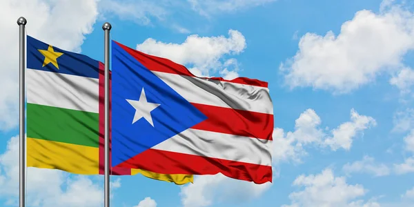 Bandera de la República Centroafricana y Puerto Rico ondeando en el viento contra el cielo azul nublado blanco juntos. Concepto diplomático, relaciones internacionales . — Foto de Stock