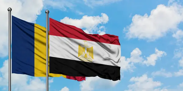 Bandera de Chad y Egipto ondeando en el viento contra el cielo azul nublado blanco juntos. Concepto diplomático, relaciones internacionales . — Foto de Stock