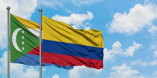 Σημαία Κομορών και Κολομβίας που κουνώντας τον άνεμο ενάντια στο λευκό συννεφιασμένο γαλάζιο του ουρανού μαζί. Φιλοσοφία της διπλωματίας, διεθνείς σχέσεις. — Φωτογραφία Αρχείου