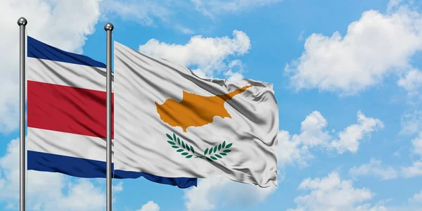 Коста-Ріка і Кіпр прапор розмахуючи в вітру проти білого хмарного синього неба разом. Концепція дипломатії, міжнародні відносини. — стокове фото