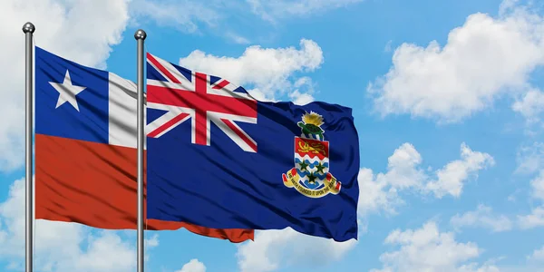 智利和开曼群岛国旗在风中飘扬，与白云蓝天相一起。外交概念、国际关系. — 图库照片