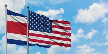 Kosta Rika ve Amerika Birleşik Devletleri bayrağı birlikte beyaz bulutlu mavi gökyüzüne karşı rüzgarda sallayarak. Diplomasi kavramı, uluslararası ilişkiler.