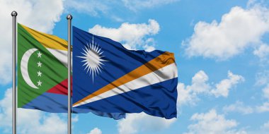 Komorlar ve Marshall Adaları bayrağı birlikte beyaz bulutlu mavi gökyüzüne karşı rüzgarda sallayarak. Diplomasi kavramı, uluslararası ilişkiler.