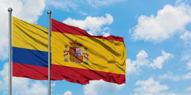 Kolombiya ve İspanya bayrağı birlikte beyaz bulutlu mavi gökyüzüne karşı rüzgarsal sallayarak. Diplomasi kavramı, uluslararası ilişkiler.