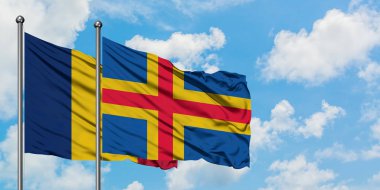 Çad ve Aland Adaları bayrağı birlikte beyaz bulutlu mavi gökyüzüne karşı rüzgarda sallayarak. Diplomasi kavramı, uluslararası ilişkiler.