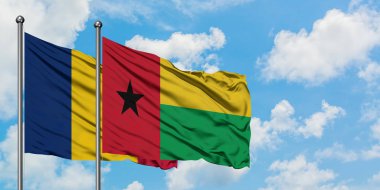 Çad ve Gine Bissau bayrağı birlikte beyaz bulutlu mavi gökyüzüne karşı rüzgarda sallayarak. Diplomasi kavramı, uluslararası ilişkiler.