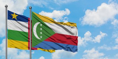 Orta Afrika Cumhuriyeti ve Komor bayrağı birlikte beyaz bulutlu mavi gökyüzüne karşı rüzgarda sallayarak. Diplomasi kavramı, uluslararası ilişkiler.