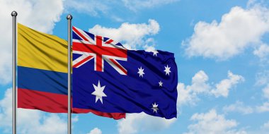 Kolombiya ve Avustralya bayrağı birlikte beyaz bulutlu mavi gökyüzüne karşı rüzgarda sallayarak. Diplomasi kavramı, uluslararası ilişkiler.