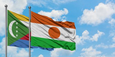 Komorlar ve Nijer bayrağı birlikte beyaz bulutlu mavi gökyüzüne karşı rüzgarda sallayarak. Diplomasi kavramı, uluslararası ilişkiler.