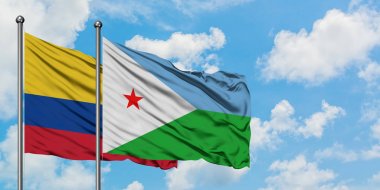 Kolombiya ve Cibuti bayrağı birlikte beyaz bulutlu mavi gökyüzüne karşı rüzgarda sallayarak. Diplomasi kavramı, uluslararası ilişkiler.