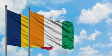 Çad ve Fildişi Sahili bayrağı birlikte beyaz bulutlu mavi gökyüzüne karşı rüzgarda sallayarak. Diplomasi kavramı, uluslararası ilişkiler.