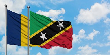 Çad ve Saint Kitts ve Nevis bayrağı birlikte beyaz bulutlu mavi gökyüzüne karşı rüzgarda sallayarak. Diplomasi kavramı, uluslararası ilişkiler.