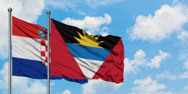 Hırvatistan ve Antigua ve Barbuda bayrağı birlikte beyaz bulutlu mavi gökyüzüne karşı rüzgarda sallayarak. Diplomasi kavramı, uluslararası ilişkiler.