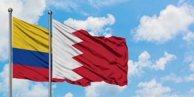 Kolombiya ve Bahreyn bayrağı birlikte beyaz bulutlu mavi gökyüzüne karşı rüzgarda sallayarak. Diplomasi kavramı, uluslararası ilişkiler.