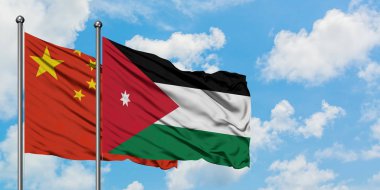 Çin ve Ürdün bayrağı birlikte beyaz bulutlu mavi gökyüzüne karşı rüzgarda sallayarak. Diplomasi kavramı, uluslararası ilişkiler.