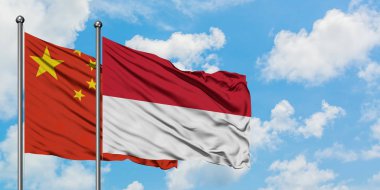 Çin ve Endonezya bayrağı birlikte beyaz bulutlu mavi gökyüzüne karşı rüzgarsal sallayarak. Diplomasi kavramı, uluslararası ilişkiler.