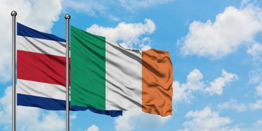 Kosta Rika ve İrlanda bayrağı birlikte beyaz bulutlu mavi gökyüzüne karşı rüzgarda sallayarak. Diplomasi kavramı, uluslararası ilişkiler.