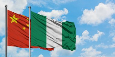 Çin ve Nijerya bayrağı birlikte beyaz bulutlu mavi gökyüzüne karşı rüzgarsal sallayarak. Diplomasi kavramı, uluslararası ilişkiler.