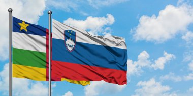 Orta Afrika Cumhuriyeti ve Slovenya bayrağı birlikte beyaz bulutlu mavi gökyüzüne karşı rüzgarsal sallayarak. Diplomasi kavramı, uluslararası ilişkiler.