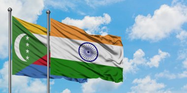 Komorlar ve Hindistan bayrağı birlikte beyaz bulutlu mavi gökyüzüne karşı rüzgarda sallayarak. Diplomasi kavramı, uluslararası ilişkiler.