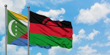 Komorlar ve Malavi bayrağı birlikte beyaz bulutlu mavi gökyüzüne karşı rüzgarda sallayarak. Diplomasi kavramı, uluslararası ilişkiler.