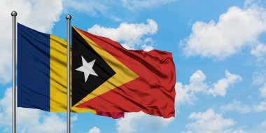 Çad ve Doğu Timor bayrağı birlikte beyaz bulutlu mavi gökyüzüne karşı rüzgarda sallayarak. Diplomasi kavramı, uluslararası ilişkiler.