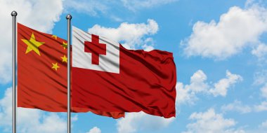 Çin ve Tonga bayrağı birlikte beyaz bulutlu mavi gökyüzüne karşı rüzgarda sallayarak. Diplomasi kavramı, uluslararası ilişkiler.