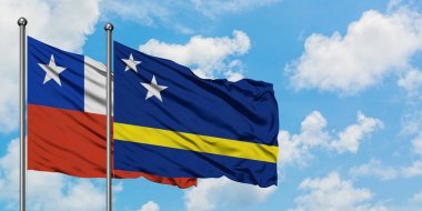 Şili ve Curacao bayrağı birlikte beyaz bulutlu mavi gökyüzüne karşı rüzgarda sallayarak. Diplomasi kavramı, uluslararası ilişkiler.