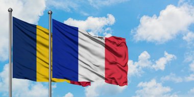 Çad ve Reunion bayrağı birlikte beyaz bulutlu mavi gökyüzüne karşı rüzgarda sallayarak. Diplomasi kavramı, uluslararası ilişkiler.