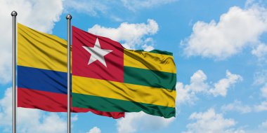 Kolombiya ve Togo bayrağı birlikte beyaz bulutlu mavi gökyüzüne karşı rüzgarda sallayarak. Diplomasi kavramı, uluslararası ilişkiler.