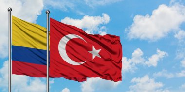 Kolombiya ve Türkiye bayrağı havada havada sallayarak beyaz bulutlu mavi gökyüzüne karşı birlikte. Diplomasi kavramı, uluslararası ilişkiler.
