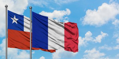 Şili ve Reunion bayrağı birlikte beyaz bulutlu mavi gökyüzüne karşı rüzgarda sallayarak. Diplomasi kavramı, uluslararası ilişkiler.