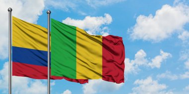 Kolombiya ve Mali bayrağı birlikte beyaz bulutlu mavi gökyüzüne karşı rüzgarda sallayarak. Diplomasi kavramı, uluslararası ilişkiler.