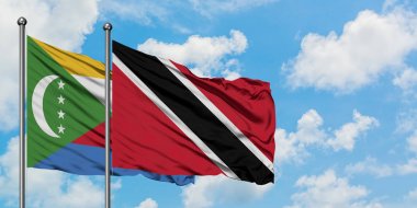 Komorlar ve Trinidad ve Tobago bayrağı birlikte beyaz bulutlu mavi gökyüzüne karşı rüzgarda sallayarak. Diplomasi kavramı, uluslararası ilişkiler.