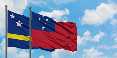 Curacao ve Samoa bayrağı birlikte beyaz bulutlu mavi gökyüzüne karşı rüzgarda sallayarak. Diplomasi kavramı, uluslararası ilişkiler.