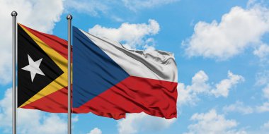 Doğu Timor ve Çek Cumhuriyeti bayrağı birlikte beyaz bulutlu mavi gökyüzüne karşı rüzgarda sallayarak. Diplomasi kavramı, uluslararası ilişkiler.