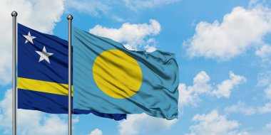 Curacao ve Palau bayrak birlikte beyaz bulutlu mavi gökyüzüne karşı rüzgarda sallayarak. Diplomasi kavramı, uluslararası ilişkiler.