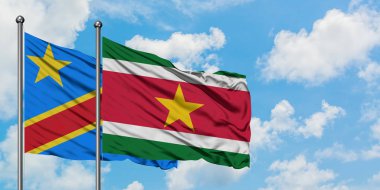 Kongo ve Surinam bayrağı birlikte beyaz bulutlu mavi gökyüzüne karşı rüzgarsal sallayarak. Diplomasi kavramı, uluslararası ilişkiler.
