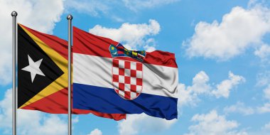 Doğu Timor ve Hırvatistan bayrağı birlikte beyaz bulutlu mavi gökyüzüne karşı rüzgarda sallayarak. Diplomasi kavramı, uluslararası ilişkiler.