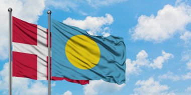 Danimarka ve Palau bayrağı birlikte beyaz bulutlu mavi gökyüzüne karşı rüzgarda sallayarak. Diplomasi kavramı, uluslararası ilişkiler.