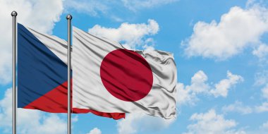 Çek Cumhuriyeti ve Japonya bayrağı birlikte beyaz bulutlu mavi gökyüzüne karşı rüzgarda sallayarak. Diplomasi kavramı, uluslararası ilişkiler.