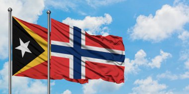 Doğu Timor ve Norveç bayrağı birlikte beyaz bulutlu mavi gökyüzüne karşı rüzgarsal sallayarak. Diplomasi kavramı, uluslararası ilişkiler.