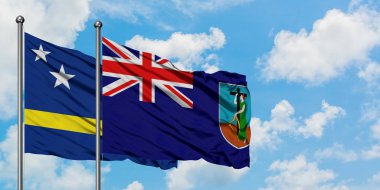 Curacao ve Montserrat bayrağı birlikte beyaz bulutlu mavi gökyüzüne karşı rüzgarda sallayarak. Diplomasi kavramı, uluslararası ilişkiler.