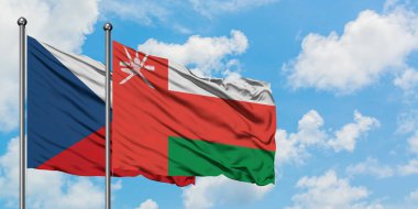 Çek Cumhuriyeti ve Umman bayrağı birlikte beyaz bulutlu mavi gökyüzüne karşı rüzgarda sallayarak. Diplomasi kavramı, uluslararası ilişkiler.