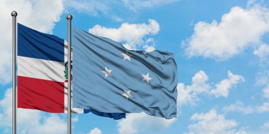 Dominik Cumhuriyeti ve Mikronezya bayrağı birlikte beyaz bulutlu mavi gökyüzüne karşı rüzgarda sallayarak. Diplomasi kavramı, uluslararası ilişkiler.