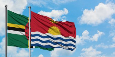 Dominika ve Kiribati bayrağı birlikte beyaz bulutlu mavi gökyüzüne karşı rüzgarda sallayarak. Diplomasi kavramı, uluslararası ilişkiler.
