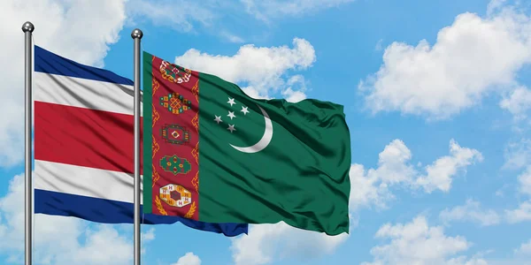 Bandera de Costa Rica y Turkmenistán ondeando en el viento contra el cielo azul nublado blanco juntos. Concepto diplomático, relaciones internacionales . — Foto de Stock