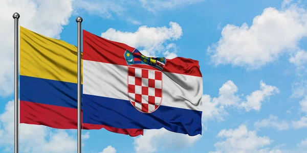 Bandera de Colombia y Croacia ondeando en el viento contra el cielo azul nublado blanco juntos. Concepto diplomático, relaciones internacionales . — Foto de Stock