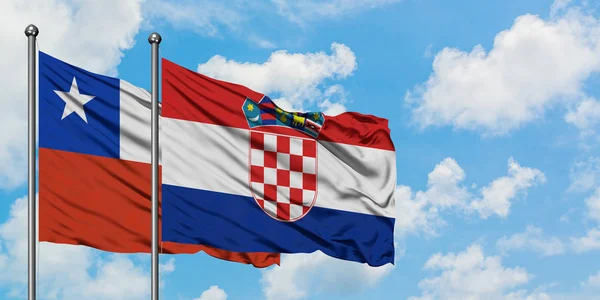 Bandera de Chile y Croacia ondeando en el viento contra el cielo azul nublado blanco juntos. Concepto diplomático, relaciones internacionales . — Foto de Stock