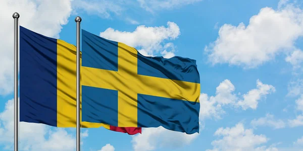 Флаг Чада и Швеции размахивает ветром против белого облачно-голубого неба вместе. Концепция дипломатии, международные отношения . — стоковое фото